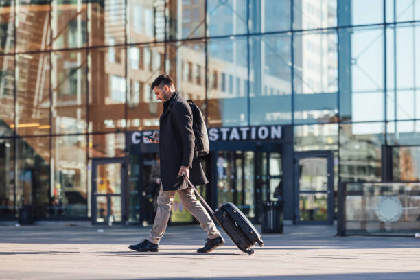 istock Happy Businessman Using A Mobile Phone At Train Station 1494628496