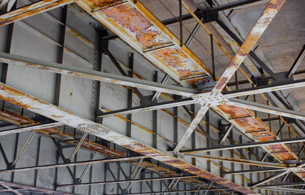 istock Old rusty reinforced concrete bridge, bottom view, main part. Construction of reinforced concrete bridges. Infrastructure, bridge building. 1494628520