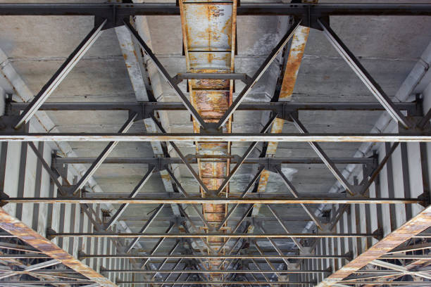 istock Old rusty reinforced concrete bridge, bottom view, main part. Construction of reinforced concrete bridges. Infrastructure, bridge building. 1494628524