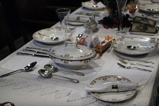 Dinner table decorated with silverware for formal supper.