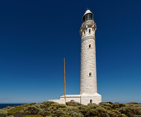 Cape Leeuwin Lighthouse located on the headland of Cape Leeuwin, the most south-westerly point on the mainland of the Australian Continent in Western Australia. White high building.