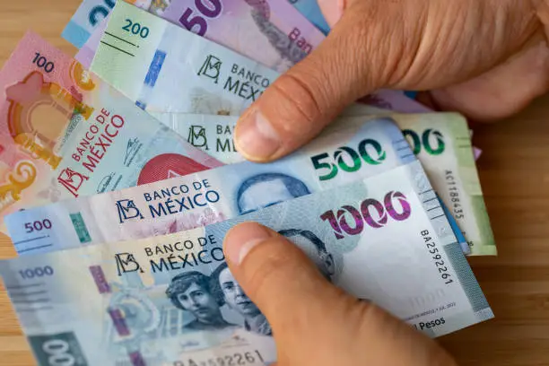 Photo of Mexico, Bundle of pesos banknotes held in hands, Financial concept, Mexican business success