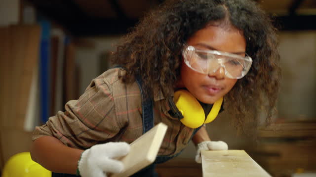 african american female carpenter working her woodworking design ideas in factory, small business concept, craft, hobby