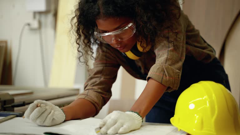 african american female carpenter working her woodworking design ideas in factory, small business concept, craft, hobby