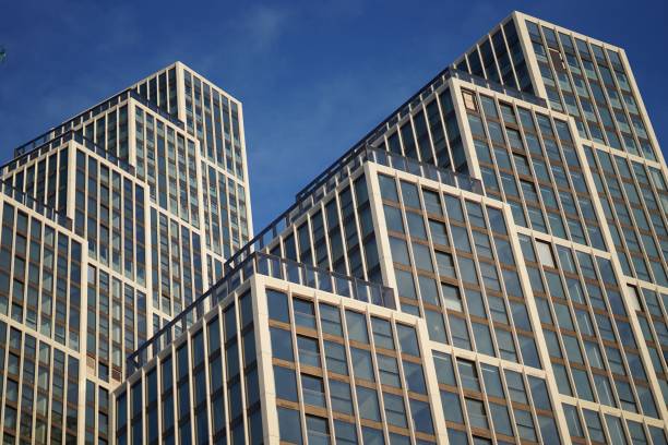 istock two very tall office buildings with windows against a blue sky 1494642054