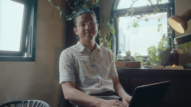 Portrait of Asian Man with Laptop in Antique Shop