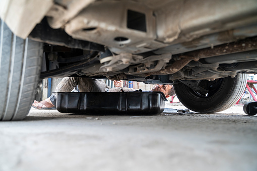 image of auto industry master doing car maintenance and repair. auto mechanic in oil and dirt. Shot with a full-frame camera in daylight.