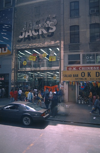 New York City, NY, USA, 1984. Street scene with busy New Yorkers and shops in downtown Manhattan.