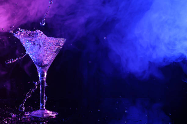 istock Fresh martini and splashes on mirror table in neon lights, space for text 1494647697