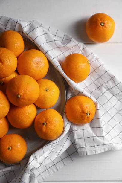 istock Many fresh ripe tangerines on white wooden table, flat lay 1494648559
