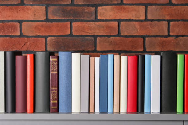 istock Many hardcover books on table near brick wall 1494648972
