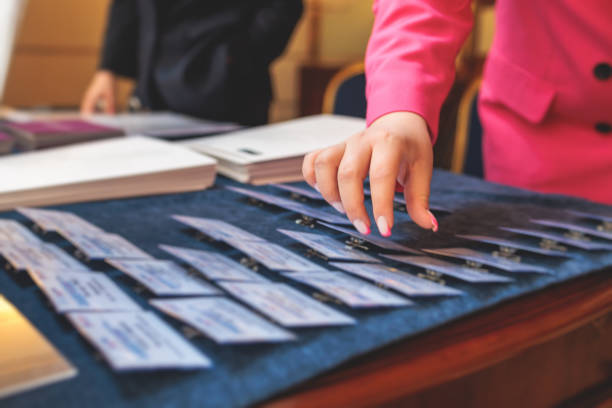 istock Process of checking in on a conference congress forum event, registration desk table, visitors and attendees receiving a name badge and entrance wristband bracelet and register electronic ticket 1494650102