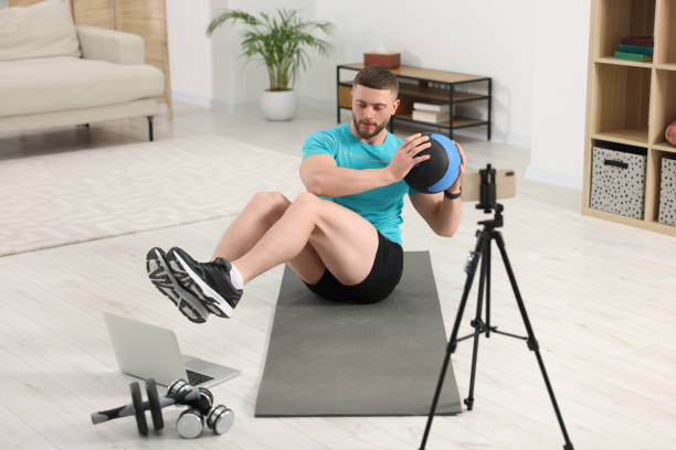 Trainer with ball streaming online workout on phone at home
