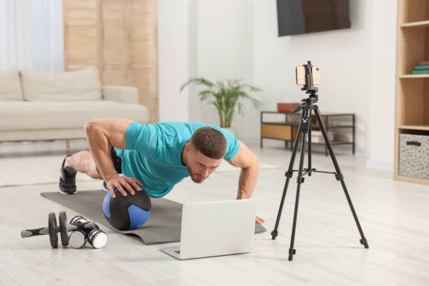 istock Trainer with ball streaming online workout on phone at home 1494650228