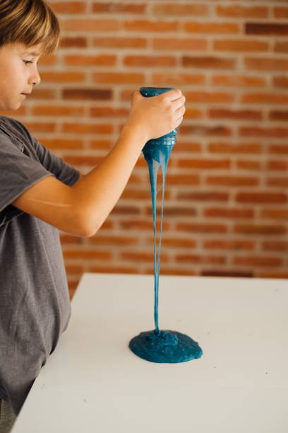 istock Little boy playing with sticky slime on the table at home 1494650321