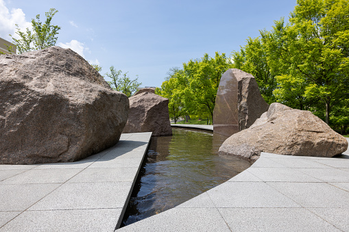 Sudama, a monumental sculptural by Elyn Zimmerman. The National Geographic Society gifted Sudama to AU and is funding all aspects of the complex installation.five enormous granite boulders and smaller accent rocks weighing more than 450,000 pounds total, which surround a crescent-shaped pool of running water.