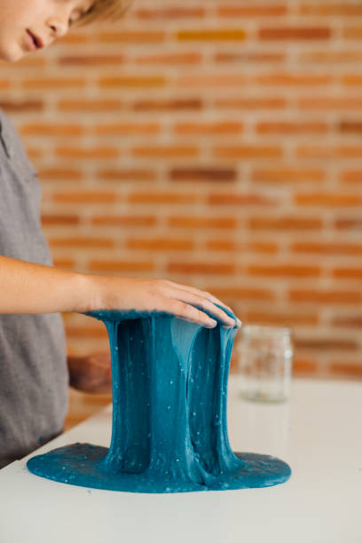 istock Little boy playing with sticky slime on the table at home 1494650351