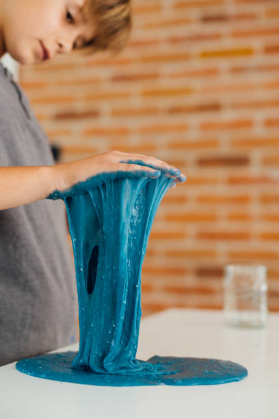 istock Little boy playing with sticky slime on the table at home 1494650368