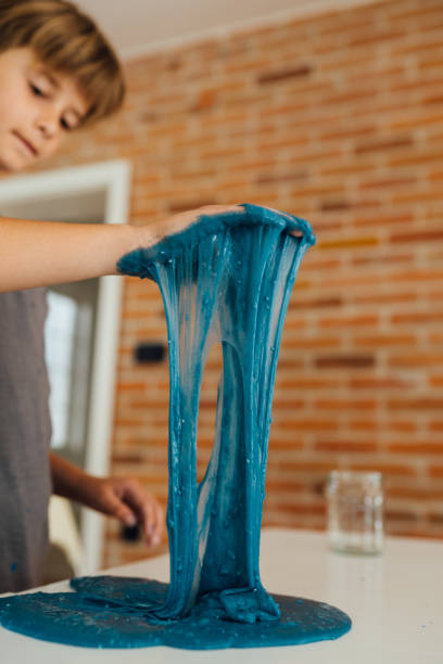 istock Little boy playing with sticky slime on the table at home 1494650389