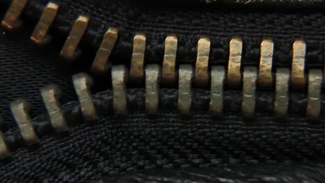 Close-up of a vintage metal zipper on a leather jacket.