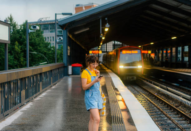 istock Woman waiting for the train on a subway station and using smartphone 1494658628