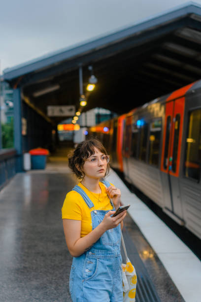 istock Woman waiting for the train on a subway station and using smartphone 1494659263