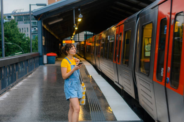 istock Woman waiting for the train on a subway station and using smartphone 1494659264