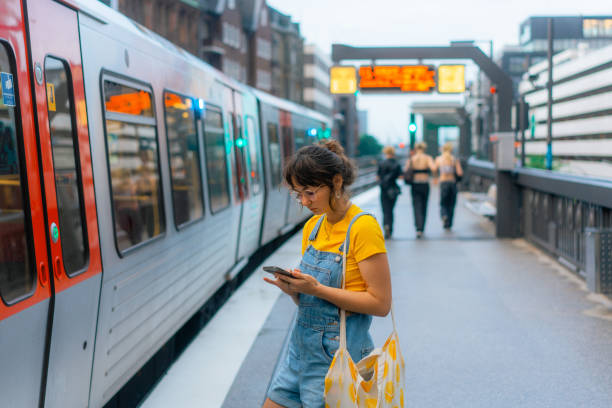 istock Woman waiting for the train on a subway station and using smartphone 1494660080