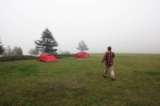 Man setting up tent for camping in mountain