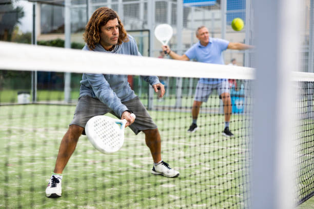istock Athletic man plays padel. View through tennis net 1494660203