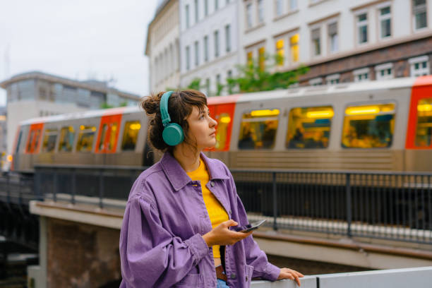 mulher que ouve a música em fones de ouvido no fundo do metrô em hamburgo - subway station subway train underground hamburg germany - fotografias e filmes do acervo