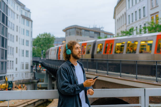 homem que ouve música em fones de ouvido no fundo do metrô em hamburgo - subway station subway train underground hamburg germany - fotografias e filmes do acervo