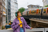 Woman listening to music in headphones on the background of subway in Hamburg