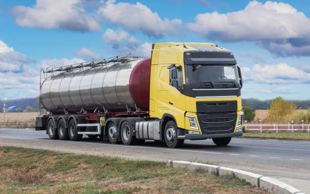 lkw mit lebensmitteltankwagen bewegt sich entlang der straße - truck fuel tanker semi truck milk tanker stock-fotos und bilder