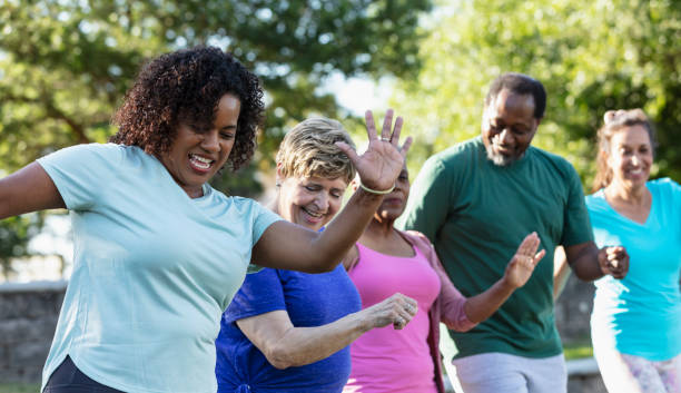 Mature and senior adults taking exercise class in park