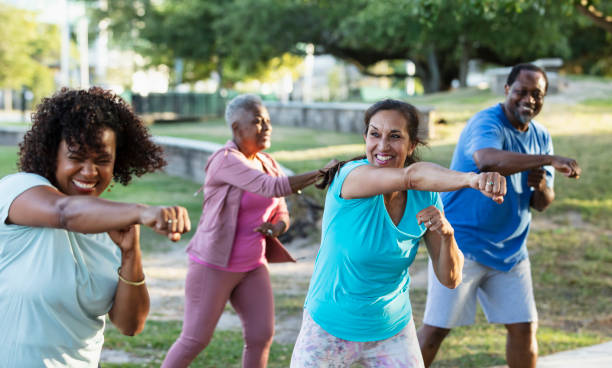istock Multiracial adults in group exercise class at park 1494661997