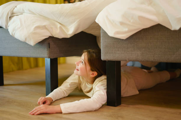 istock Little pretty girl hiding under bed 1494663981