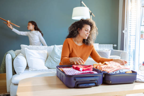 istock Mother packing clothes in suitcase for a summer vacation 1494665670