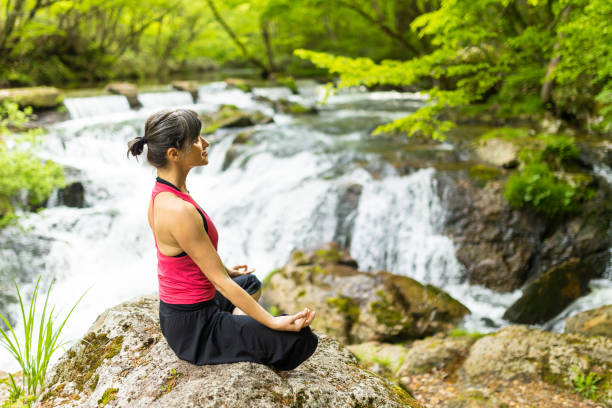 istock A woman meditating by a waterfall 1494669358