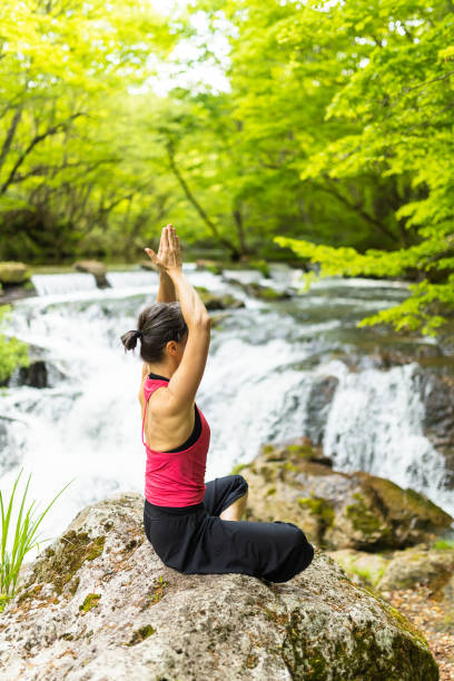 istock A woman meditating by a waterfall 1494669361