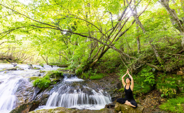 istock A woman meditating by a waterfall 1494669386