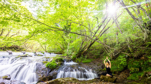 istock A woman meditating by a waterfall 1494669390