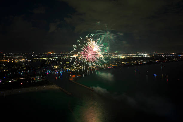 vista aérea de fogos de artifício brilhantes explodindo com luzes coloridas sobre a costa do mar no feriado do dia da independência dos eua - exploding celebration multi colored colors - fotografias e filmes do acervo