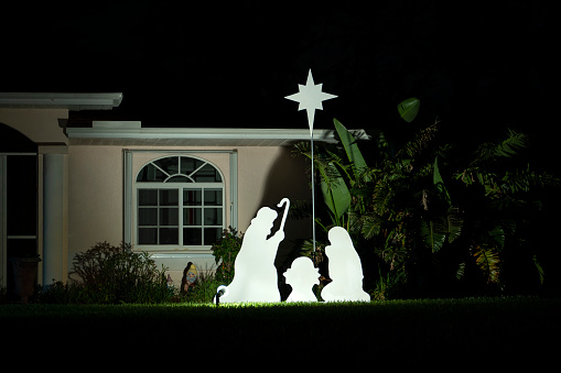 Brightly illuminated christmas decorations on front yard of florida family home. Outside decor for winter holidays.