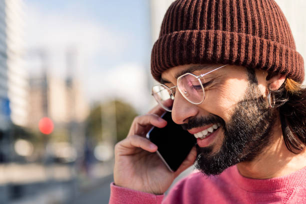 istock stylish man smiling happy talking on smart phone 1494677131
