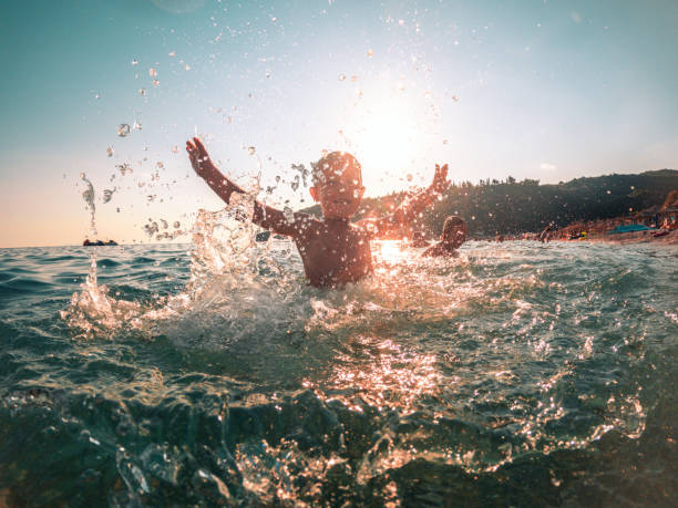 istock Active Boy Splashing Water with Both Arms Up 1494679123