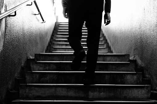 Image below the waist of a man climbing the stairs