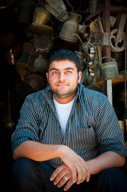 A coppersmith sitting at the entrance to his shop in Aleppo, Syria