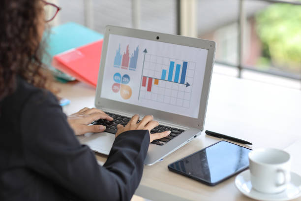 istock Attractive professional latin female employee worker hands, using laptop computer with tablet at home workplace. Rear view businesswoman working on graph while typing notebook 1494692781