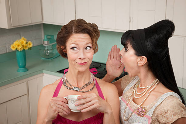 Woman Whispering Secret Retro styled woman whispers secret into friend's ear retro 1950s kitchen stock pictures, royalty-free photos & images